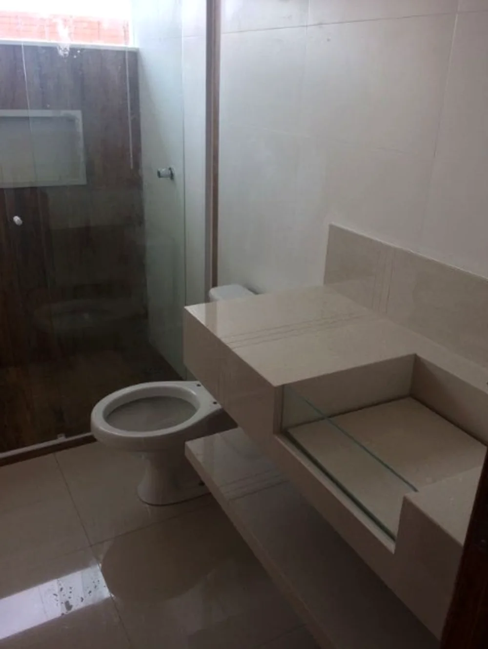 Banheiro com box de vidro e bancada em pedra